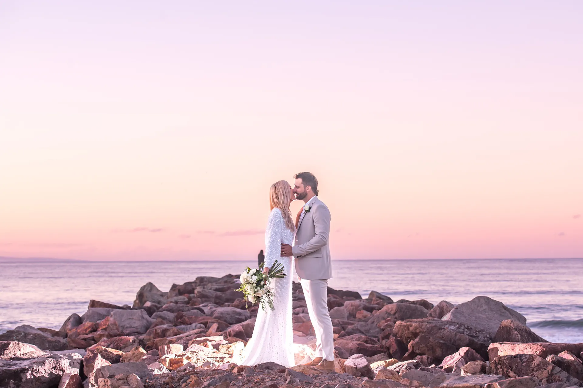 A couple embracing at their Noosa Beach Sunset Wedding