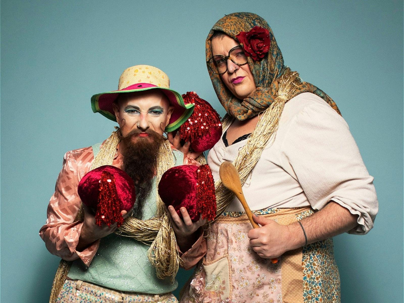 A person wearing boxing gloves & a person in drag dressed as an old woman