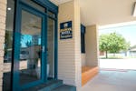 Front reception area of Holbrook Motel with navy blue doors and white brick walls