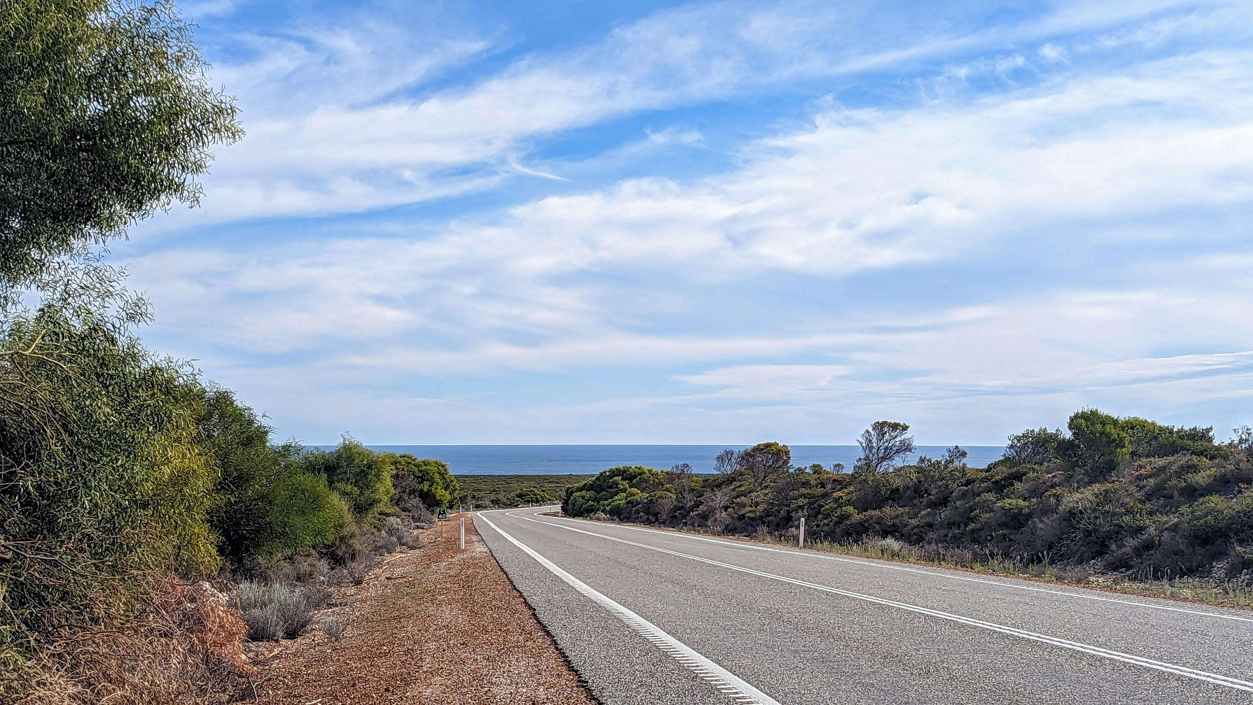 Picture of a highway curving towards the turquoise waters of the Indian Ocean