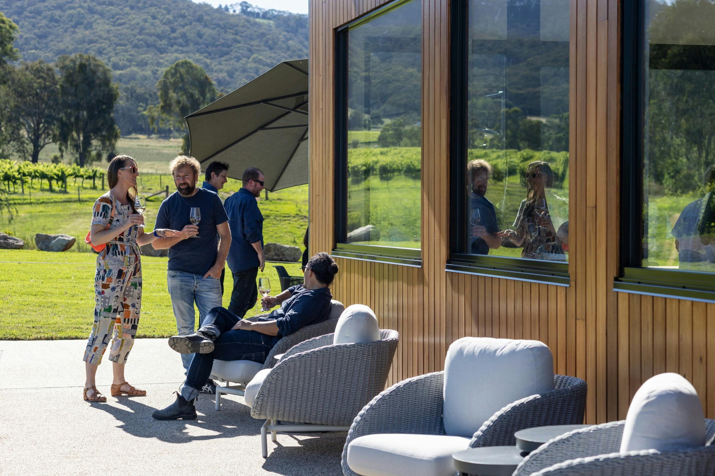 Guests enjoying a glass of wine at the outdoor lounge seats.