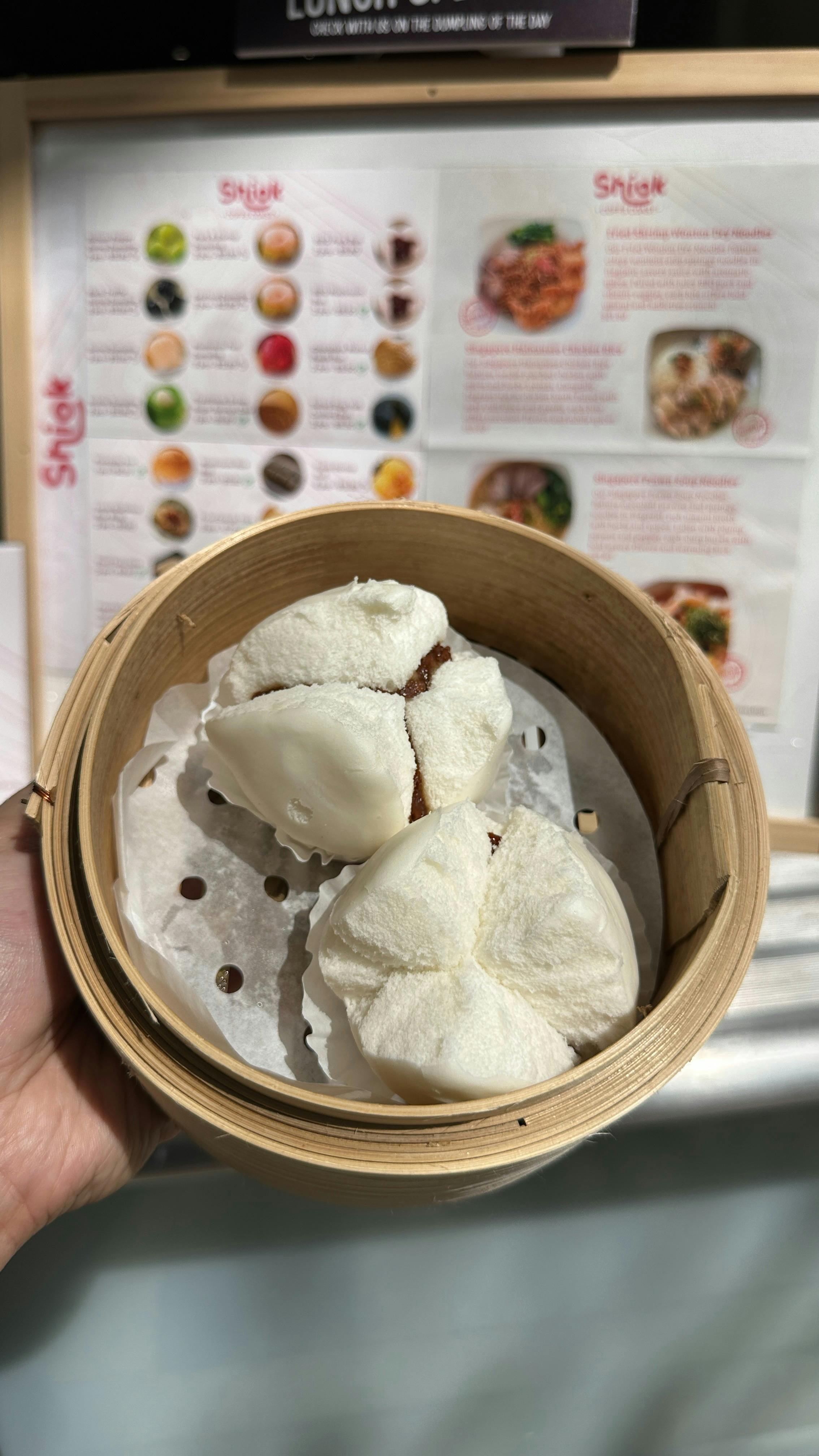 Steamed fluffy BBQ pork buns (char siu bao) split open in a bamboo steamer.