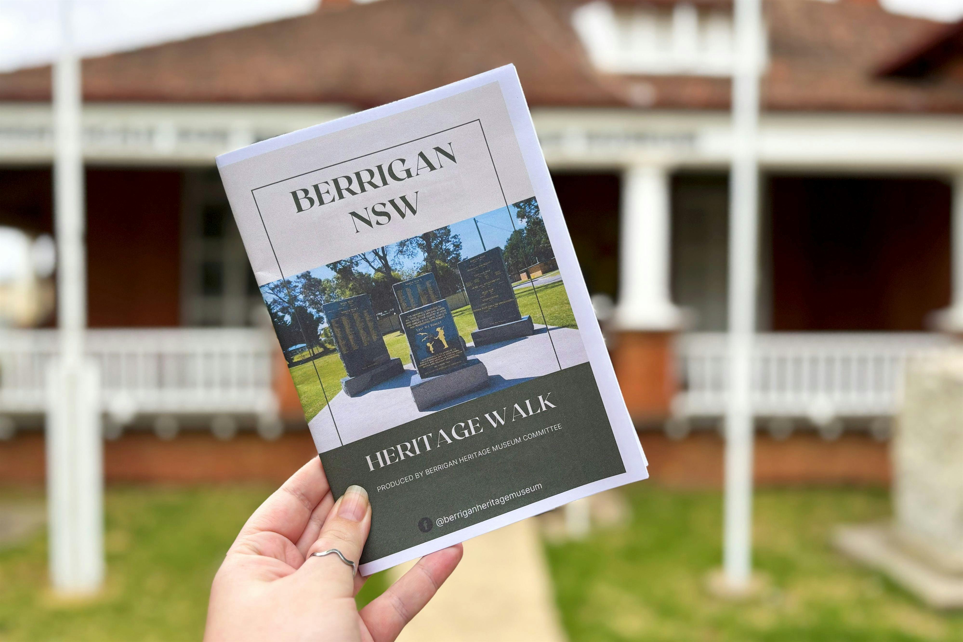 Hand holding Heritage Walk brochure outside Museum building