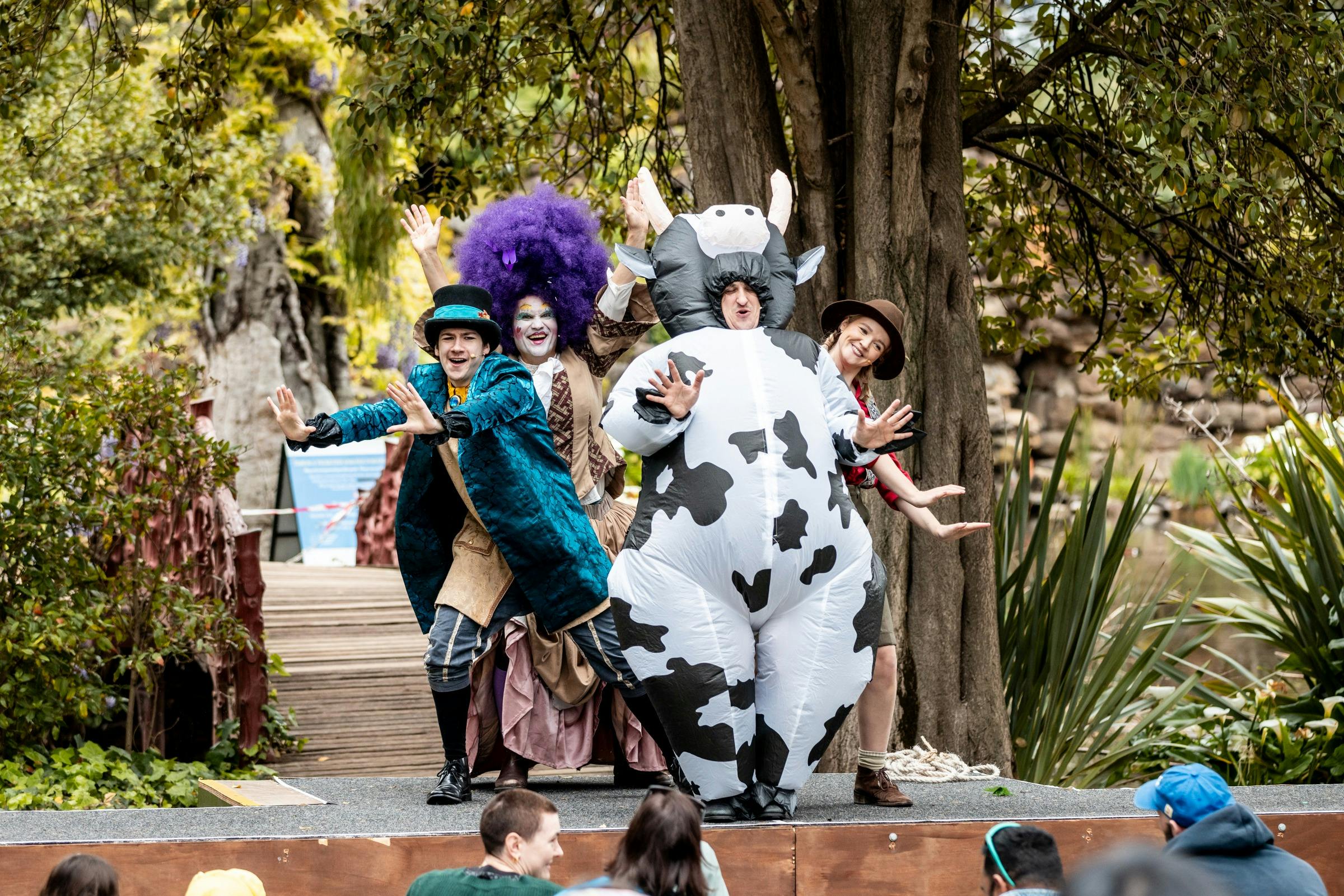 Several Jack and the Beanstalk characters, including a cow, stand in a group on stage.
