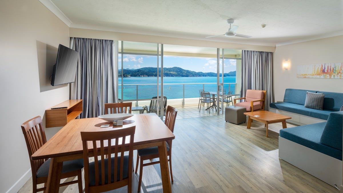 Apartment dining and living area with balcony view of Catseye Beach