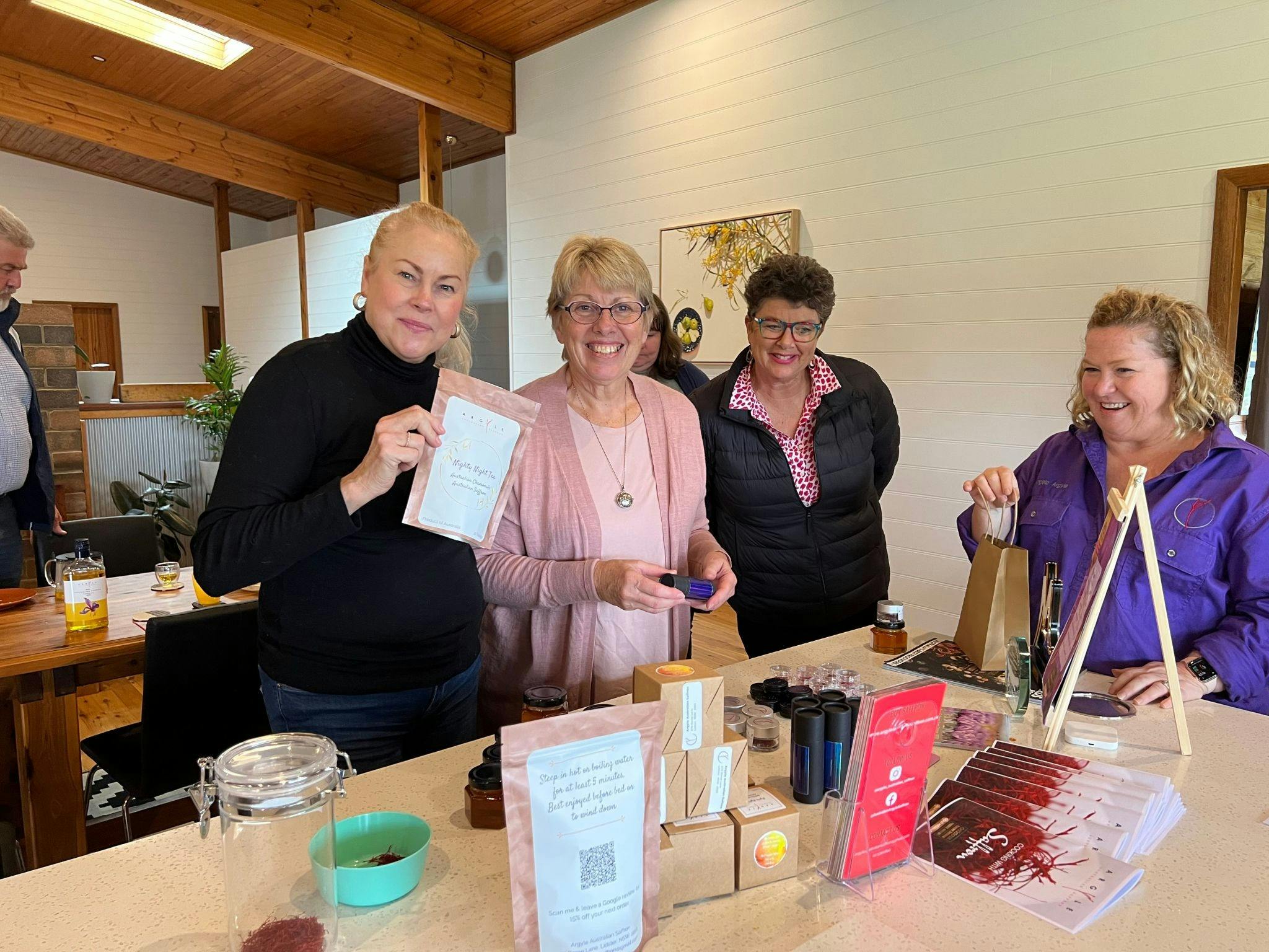4 ladies holding saffron products on saffron trail tour