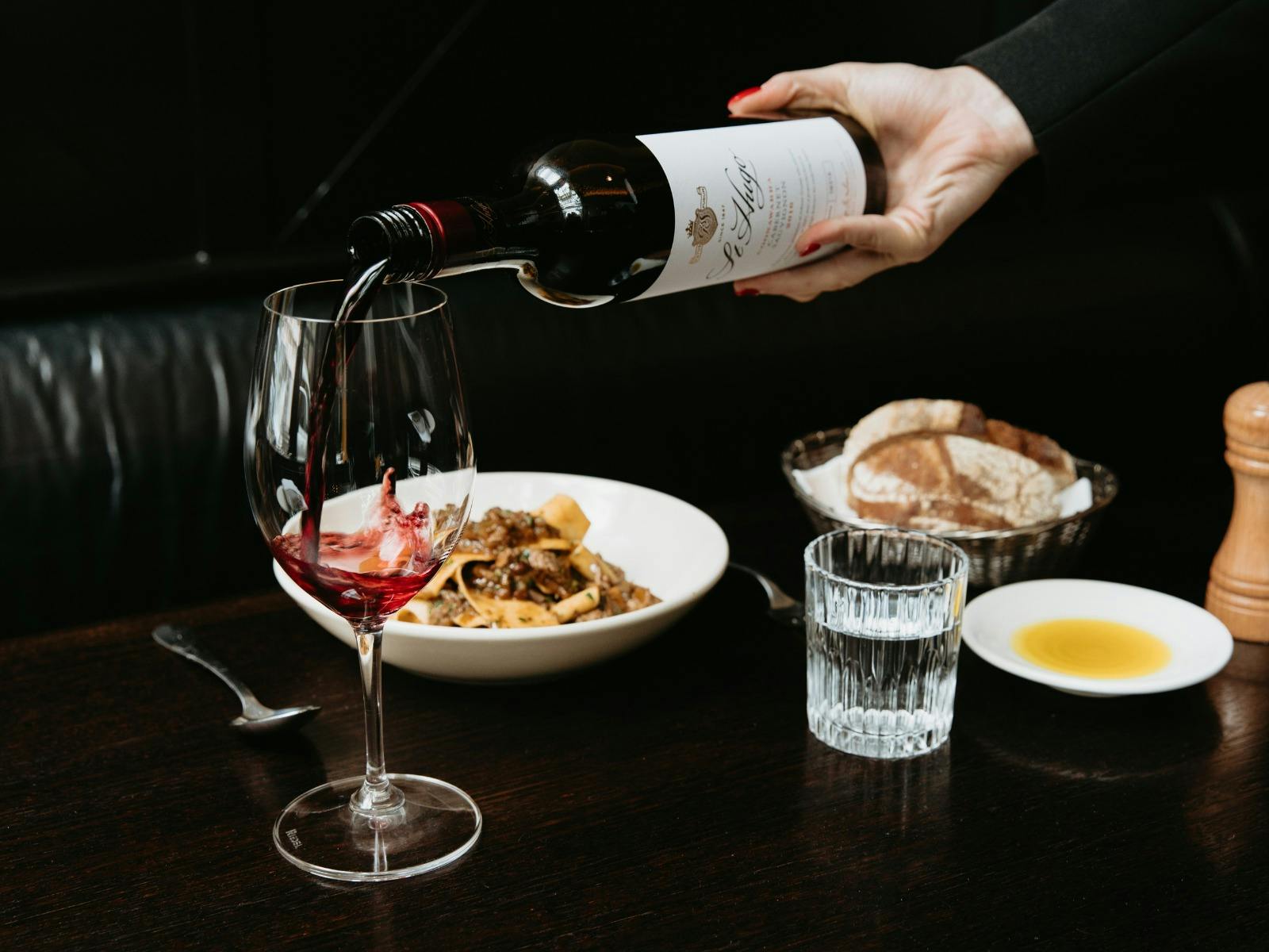 St Hugo wine being poured into a glass on the table