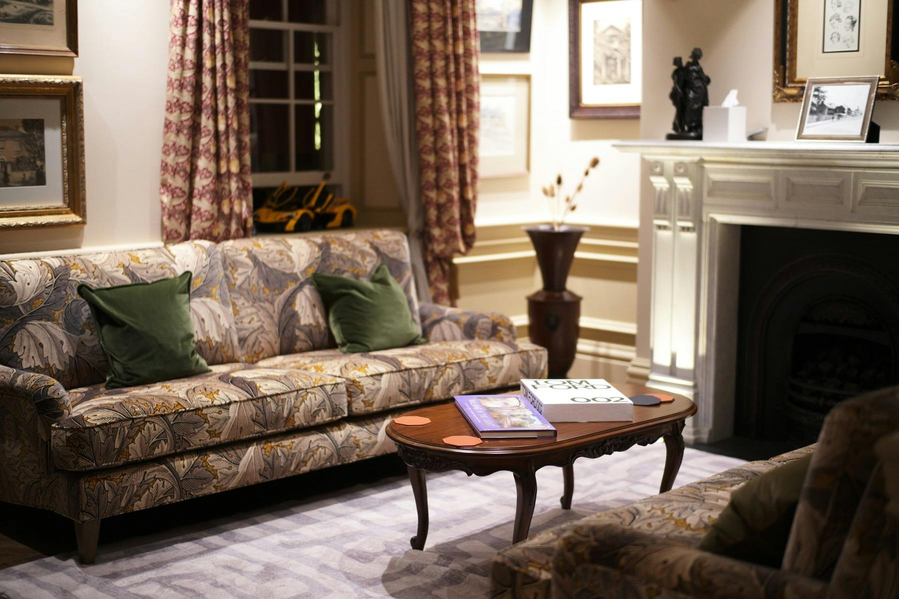 時尚的休息室，配有大理石壁爐、復古沙發和現代地毯。