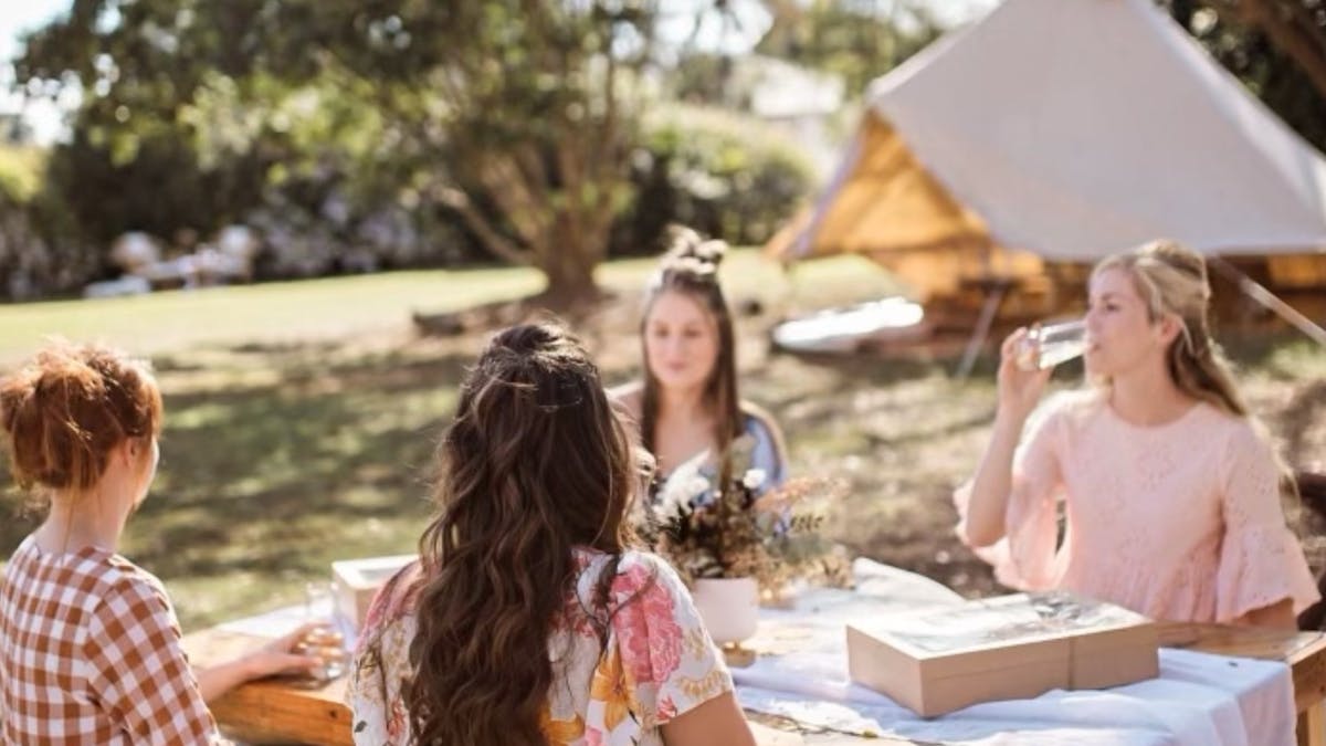 Group of ladies sitting around our bespoke sunshine styled picnic at The Soul Nook