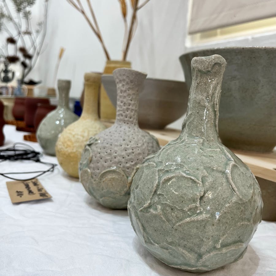 Images shows 4 vases in a row on a table