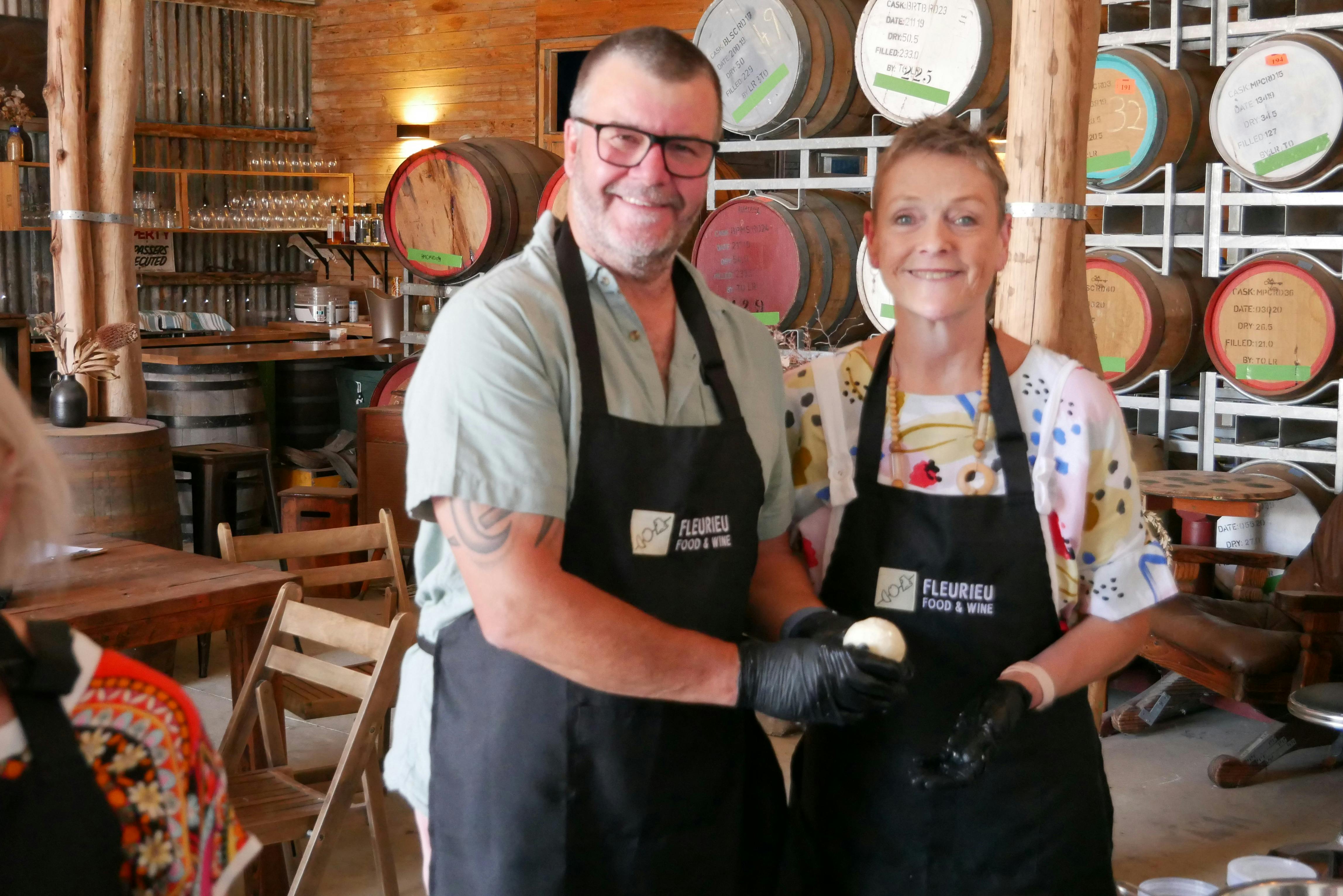 a couple holding up their Mozzarella made in a Fleurieu Food and Wine Cooking Class