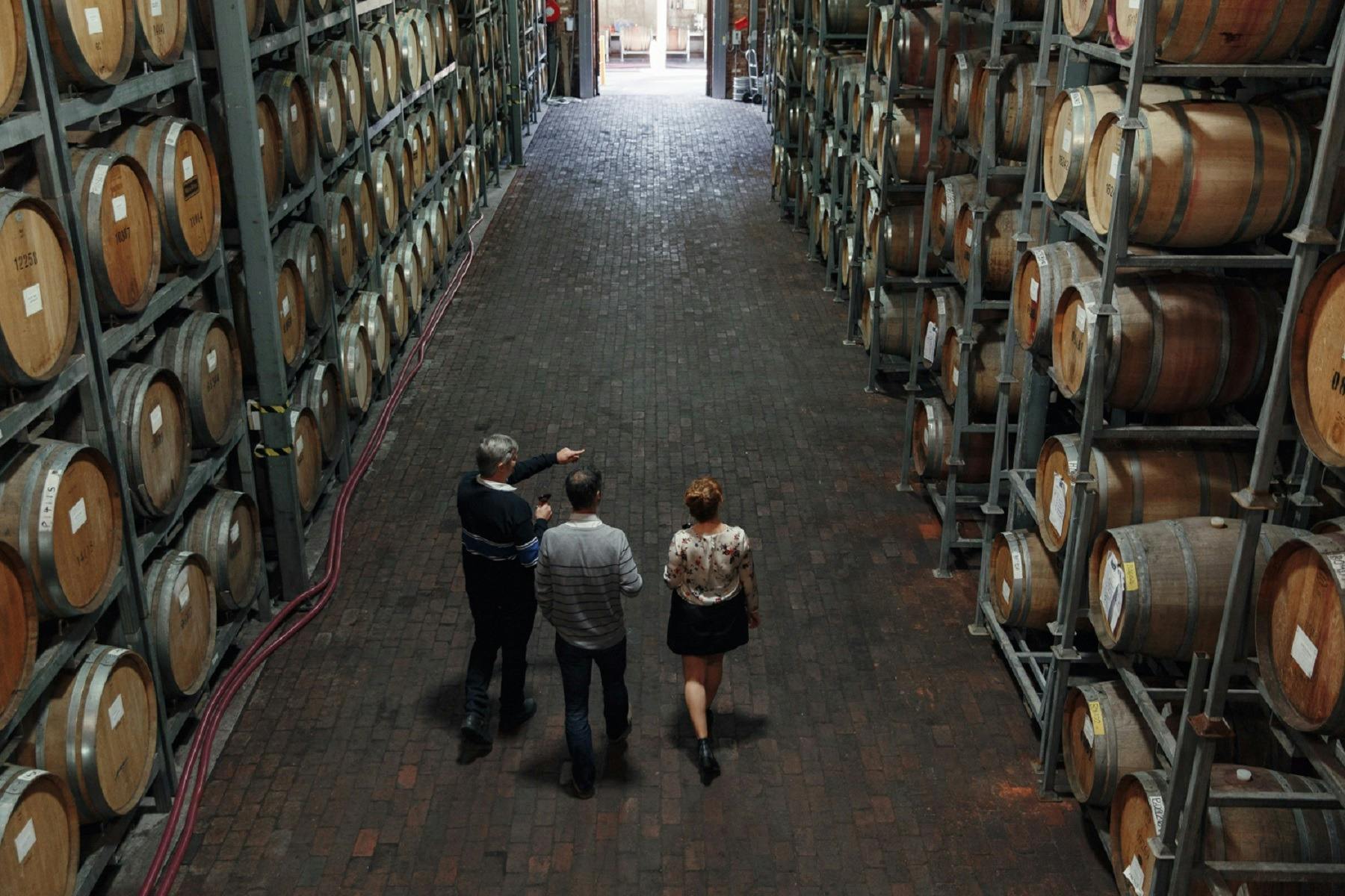 Group of three people walking through a Barrel Hall