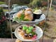 A three tiered stand of high tea sweet and savoury pastries, scones jam and cream.