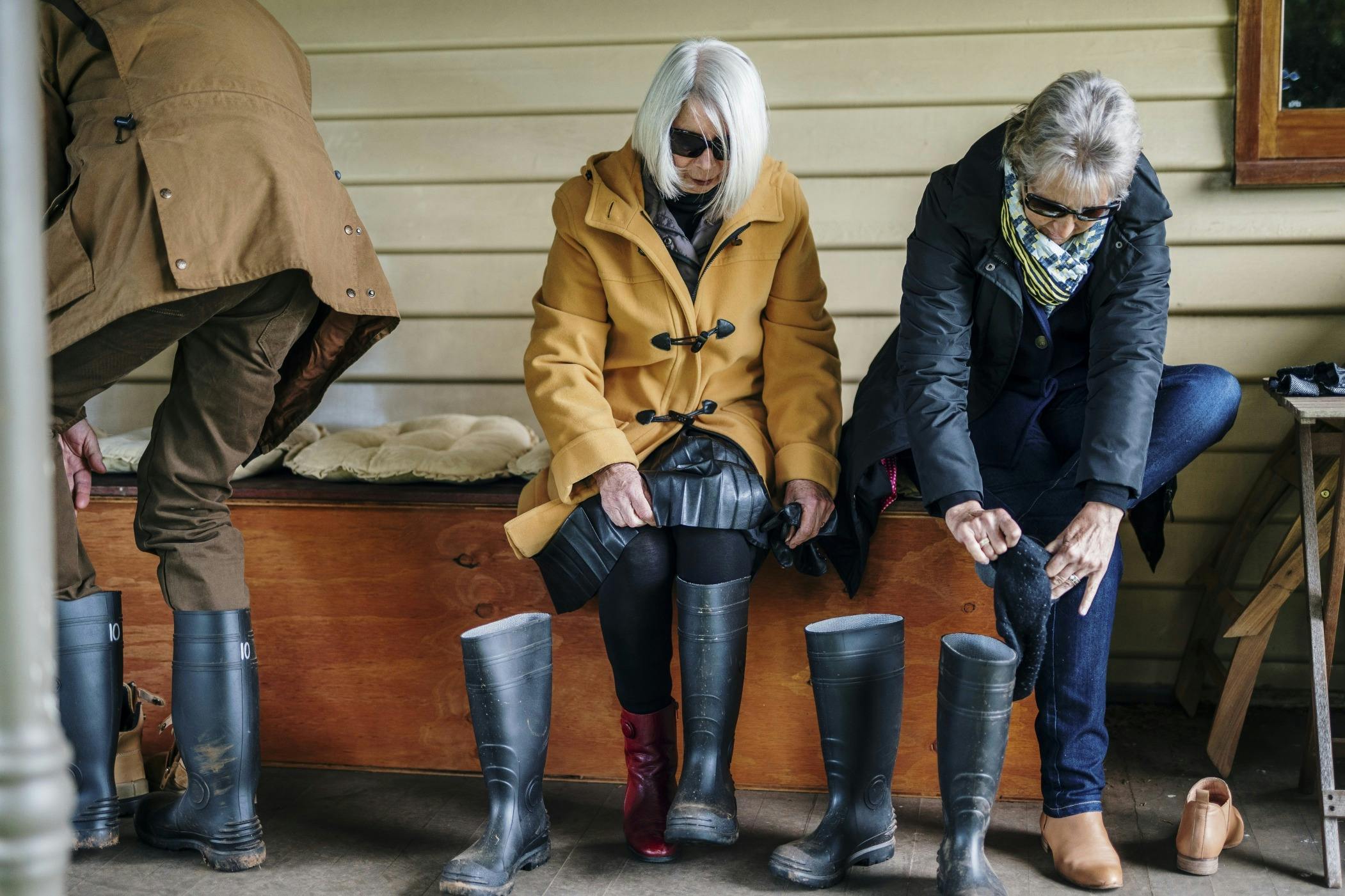 Two ladies putting on gum boots