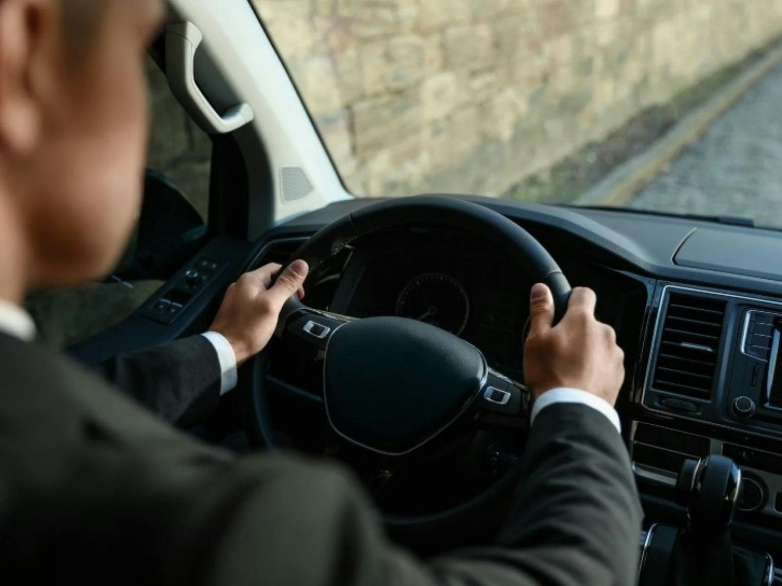 close up of a driver holding the wheel of a taxi