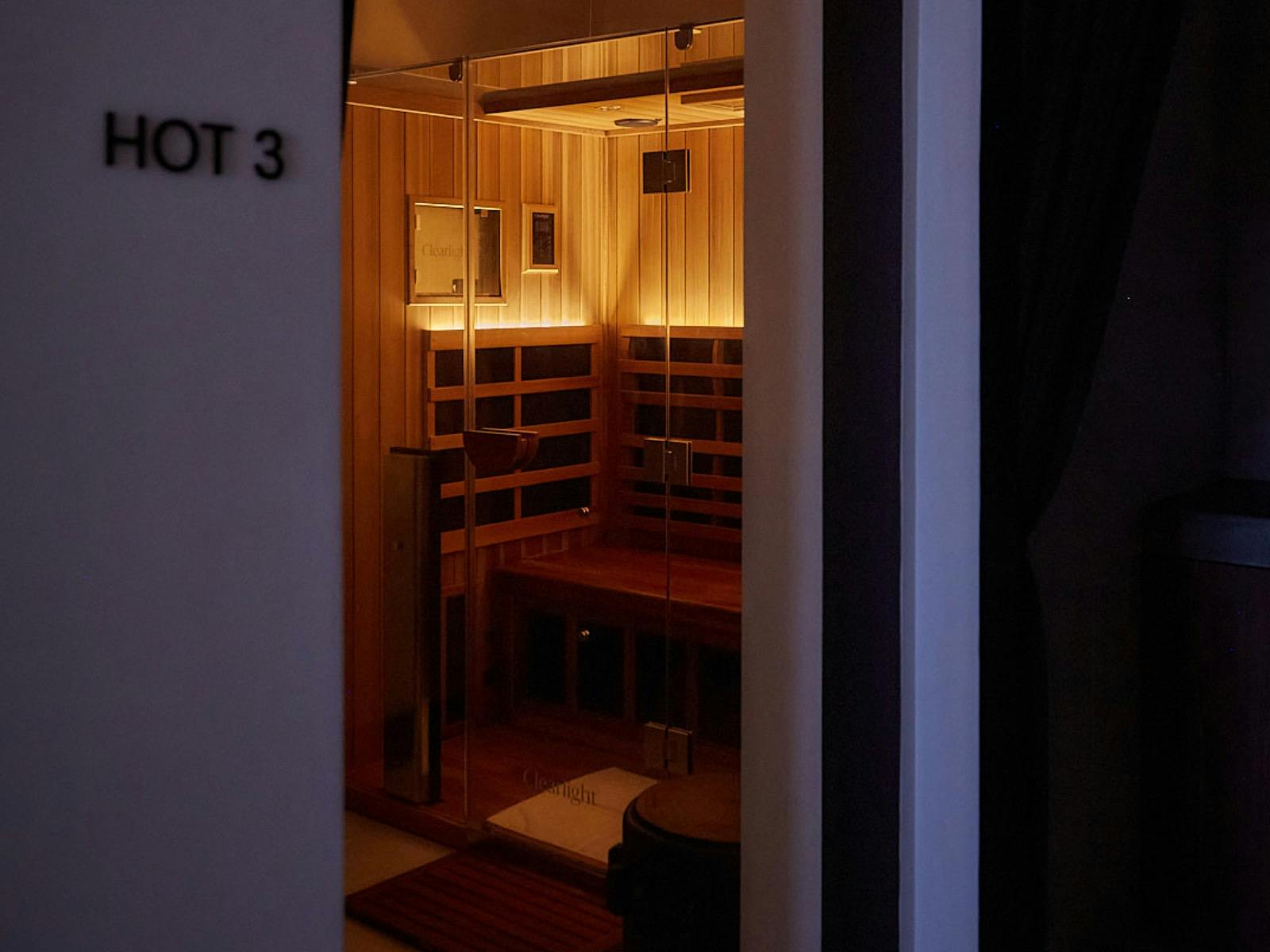 picture looking through an archway of a double infrared sauna with the lights on.