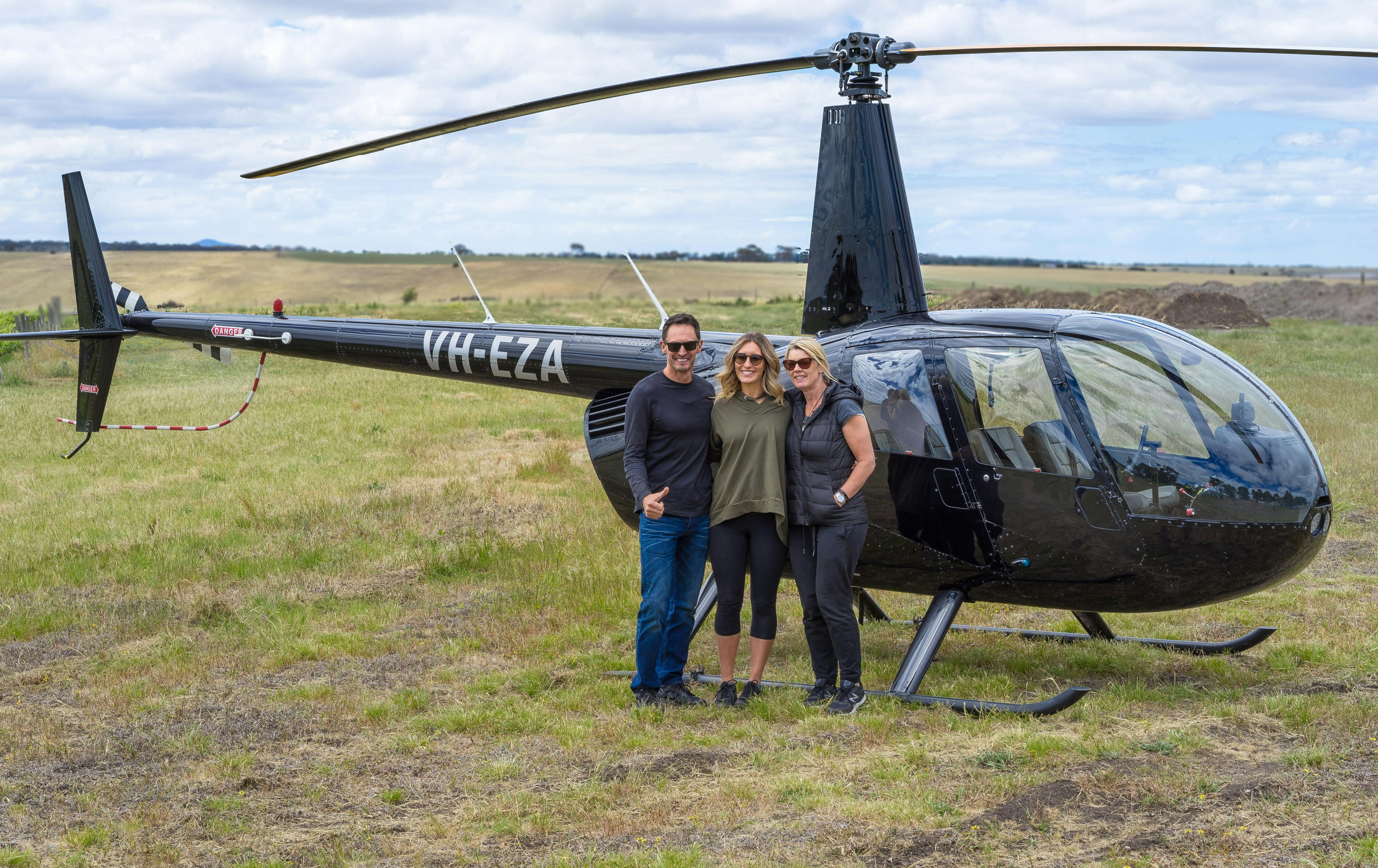 Passengers standing beside Melbourne Heli's helicopter at Clyde Park winery.