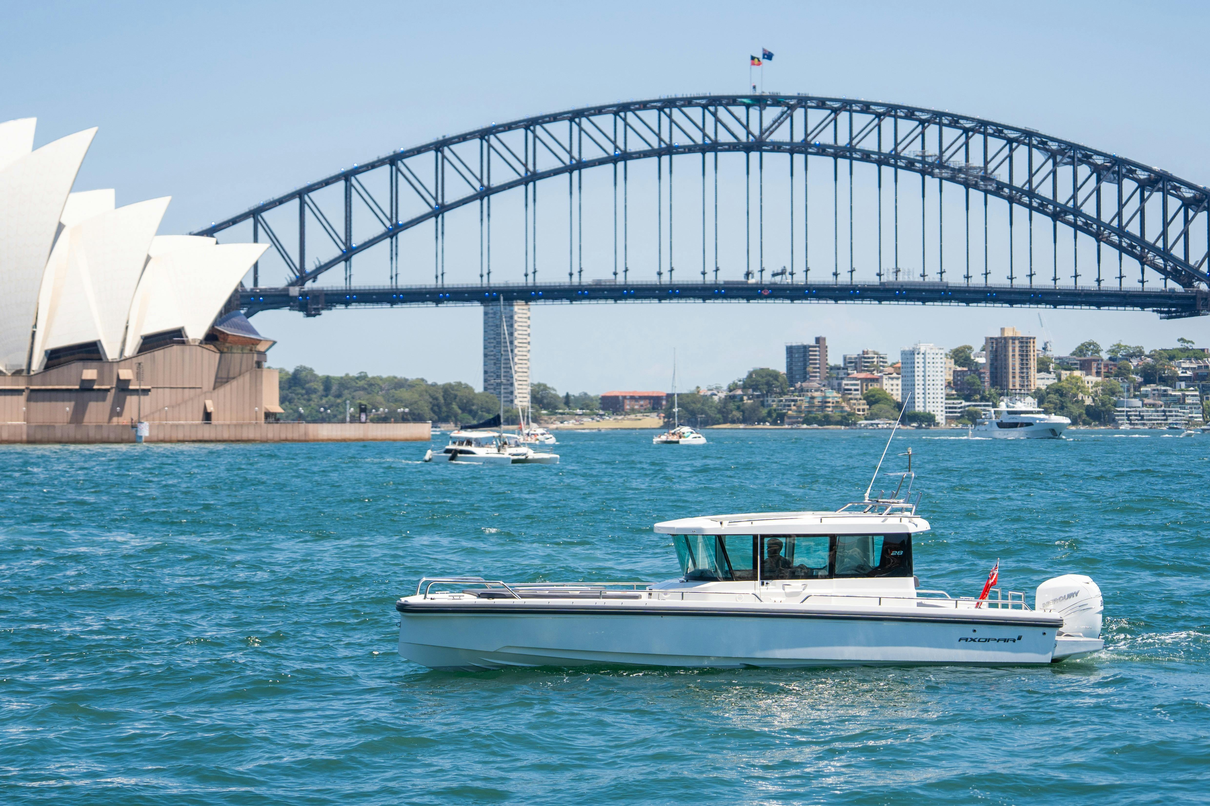 Luxury motor yacht cruising on Sydney Harbour with city skyline in the background