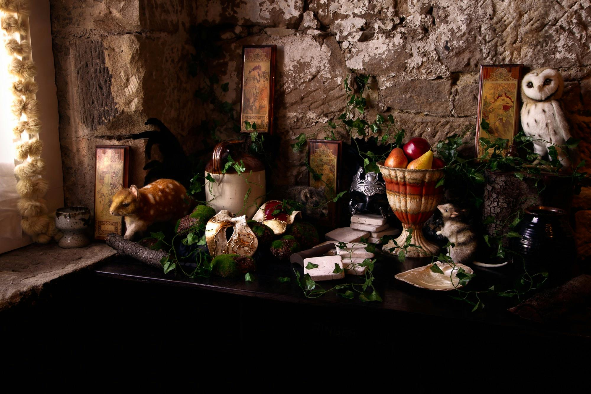 A table set with vines, native animals, fruit and masks reminiscent of ancient ruins