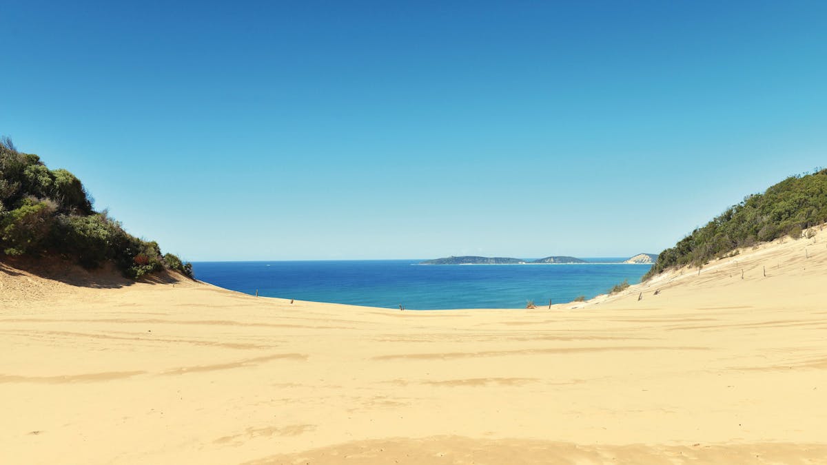 Carlo Sandblow sand dune with Double Island Point in distance. Carlo Sandblow sand dune with Double Island Point in distance.