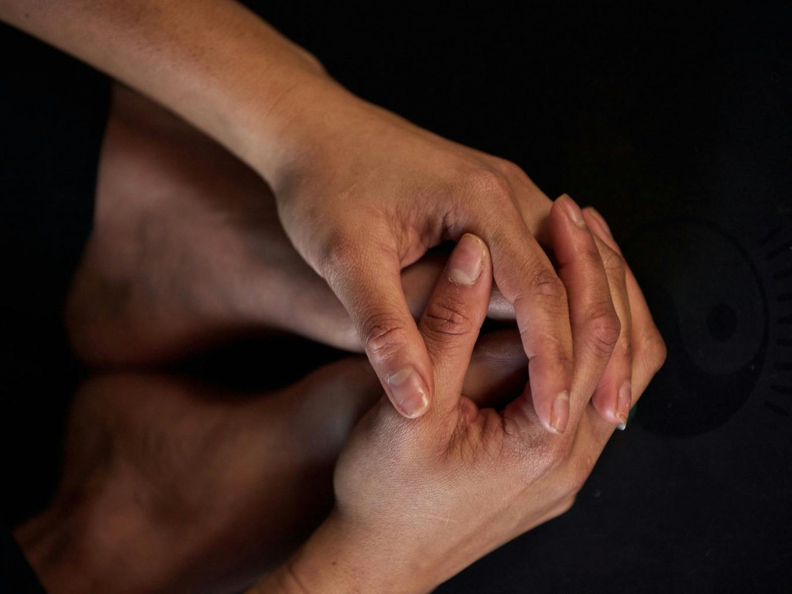 Hands cupping feet in yoga