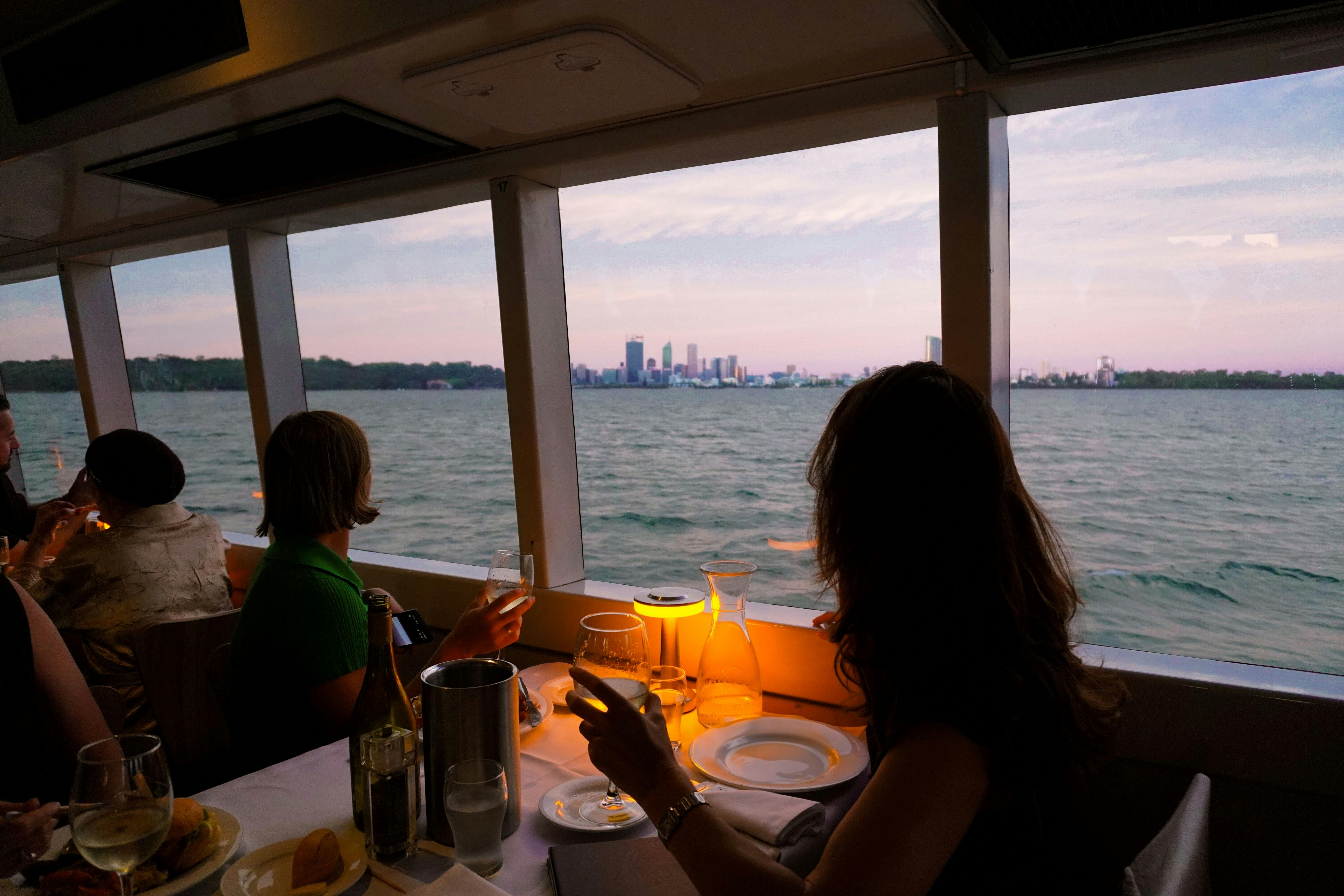 A person sitting on the front a vessel traversing a narrow river