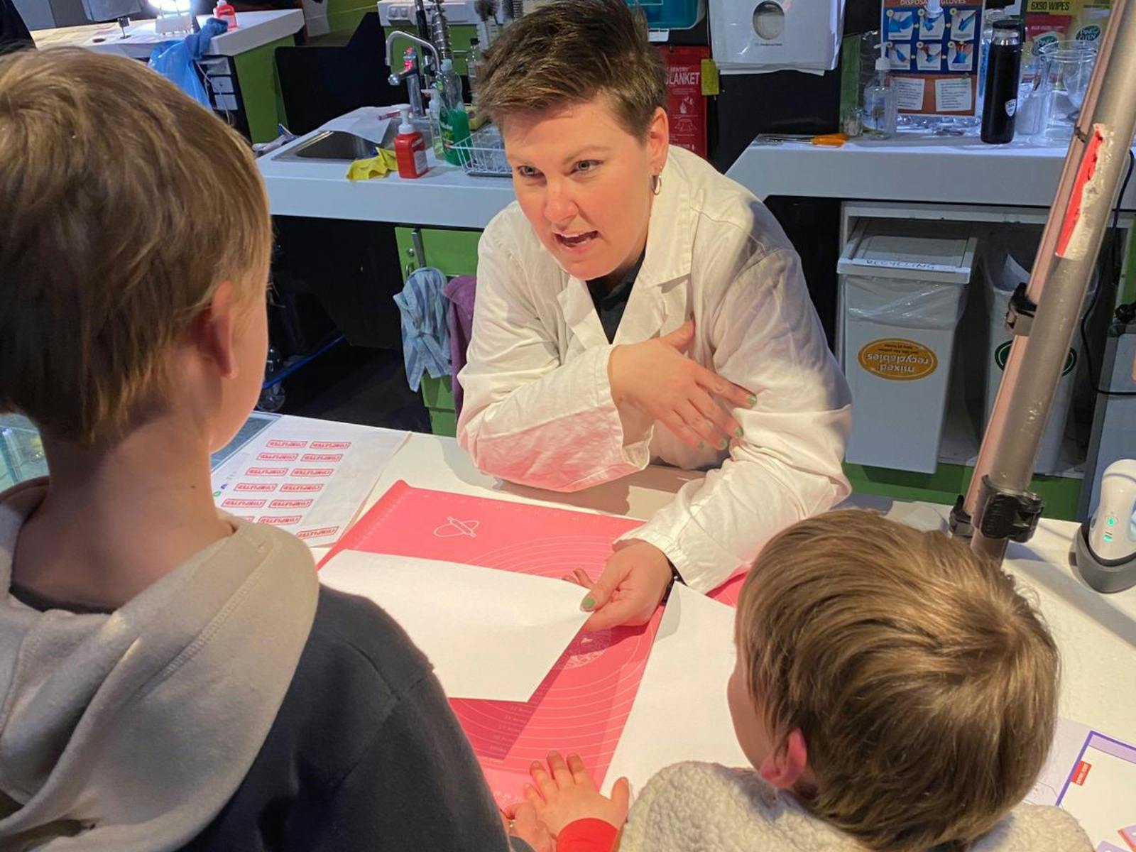 Forensic AFP personnel showing forensic science to two young boys