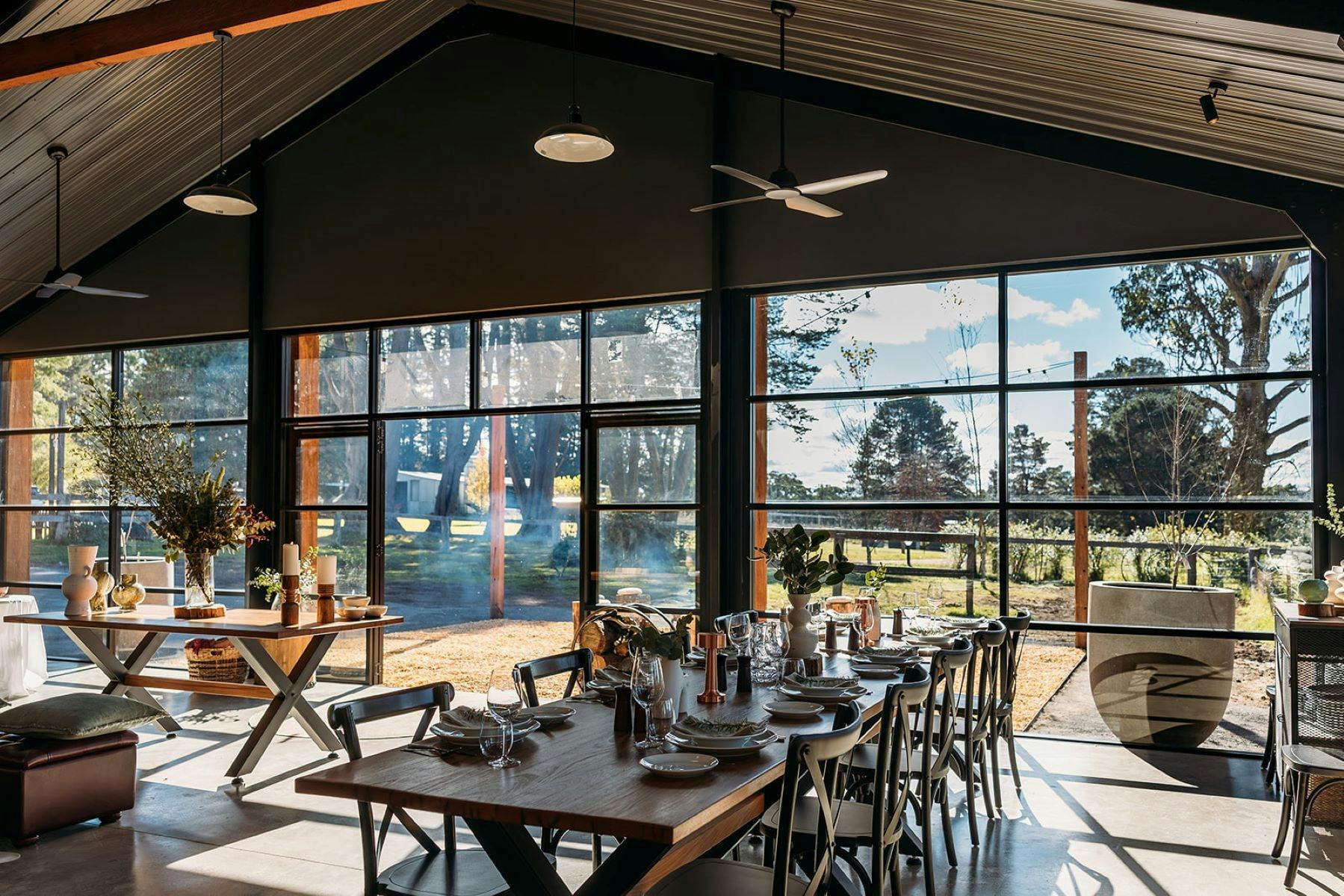 Inside event hire area showing table set up for work corporate meeting with large windows light in