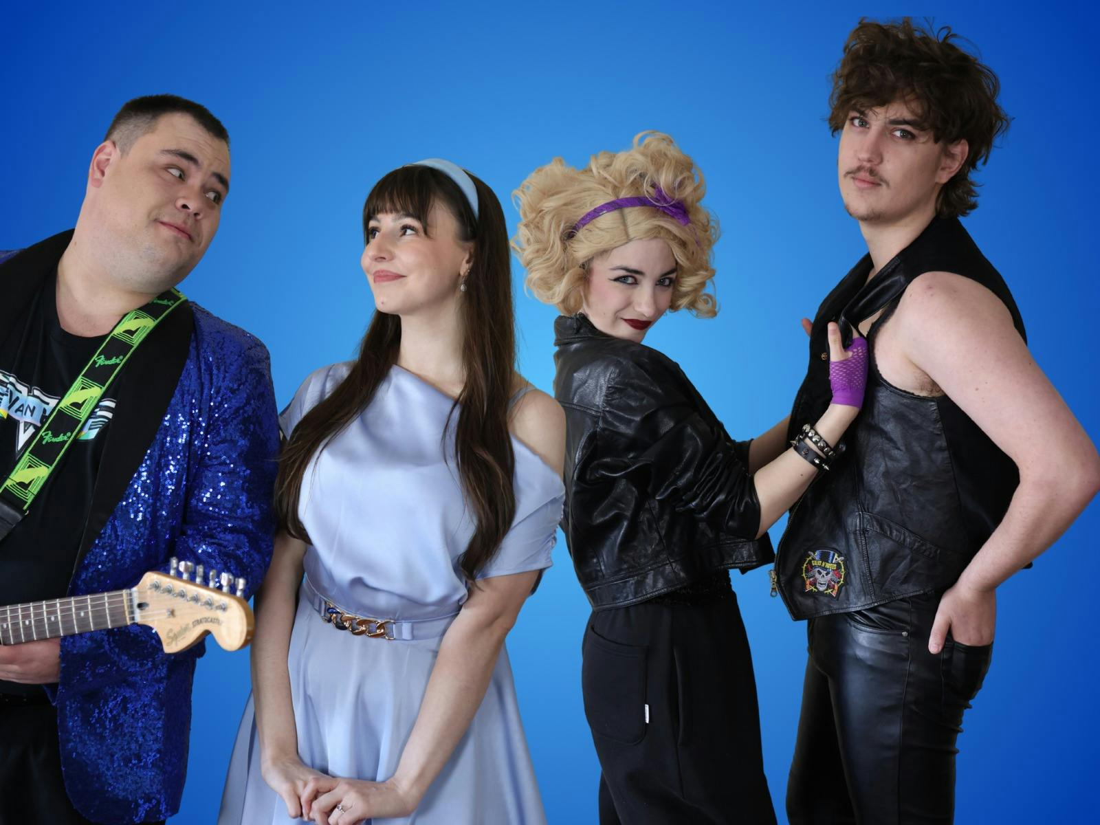 Robbie, Julia, Holly and Sammy posing together wearing colourful 80s inspired costumes