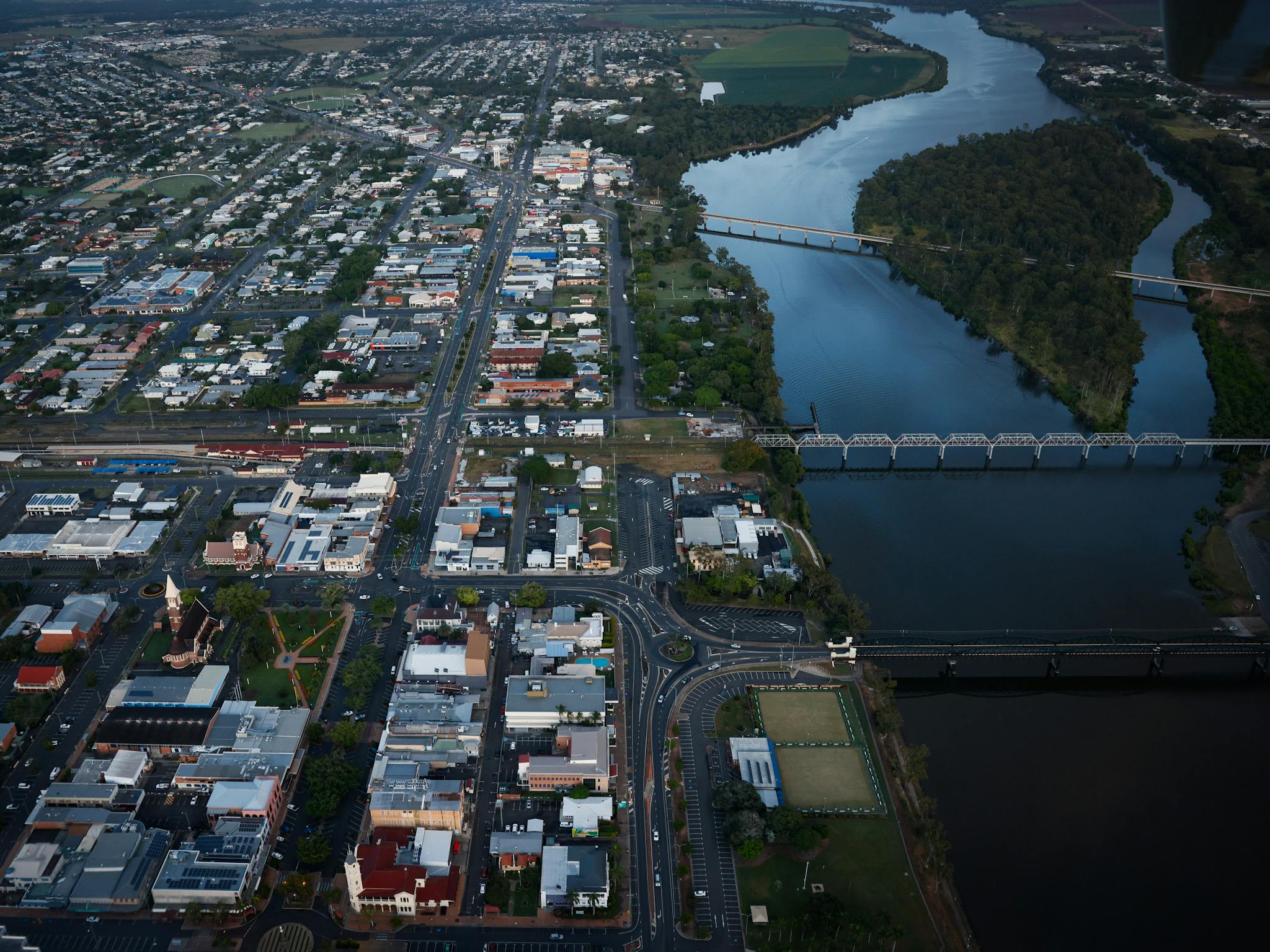 Aerial view of Bundaberg CBD and river separating the City, with its iconic heritage bridges, the Aerial view of Bundaberg CBD and river separating the City, with its iconic heritage bridges, the