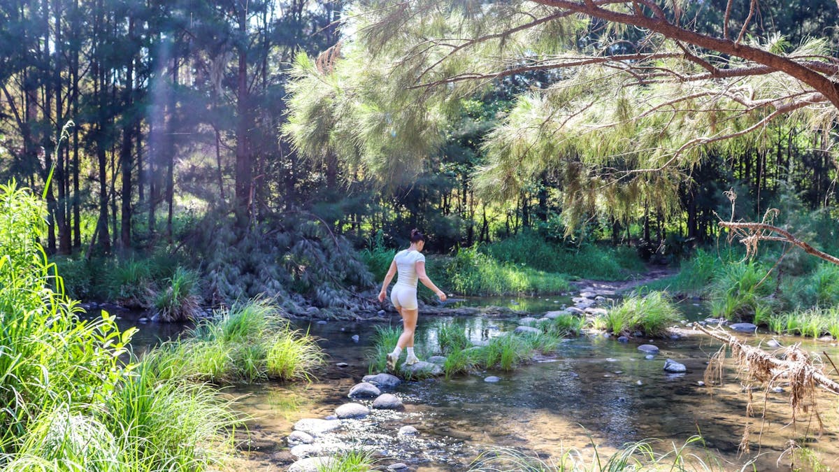 Female completing a creek crossing in Carnarvon Gorge.