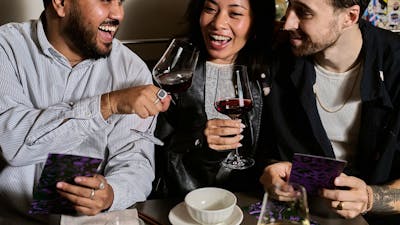 Two men and one woman enjoying a glass of wine before their dinner arrives.