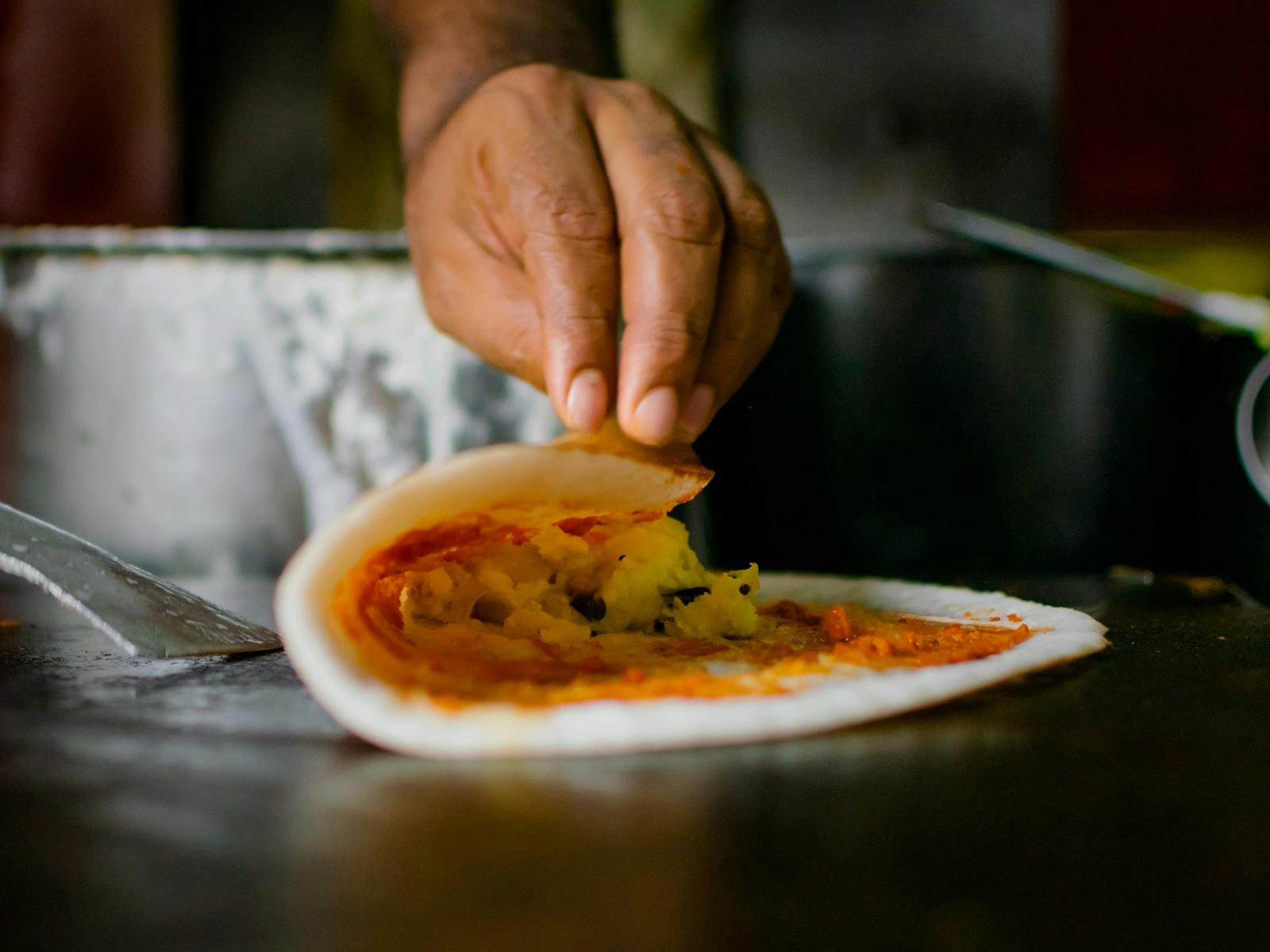 A dosa is cooking on a hotplate
