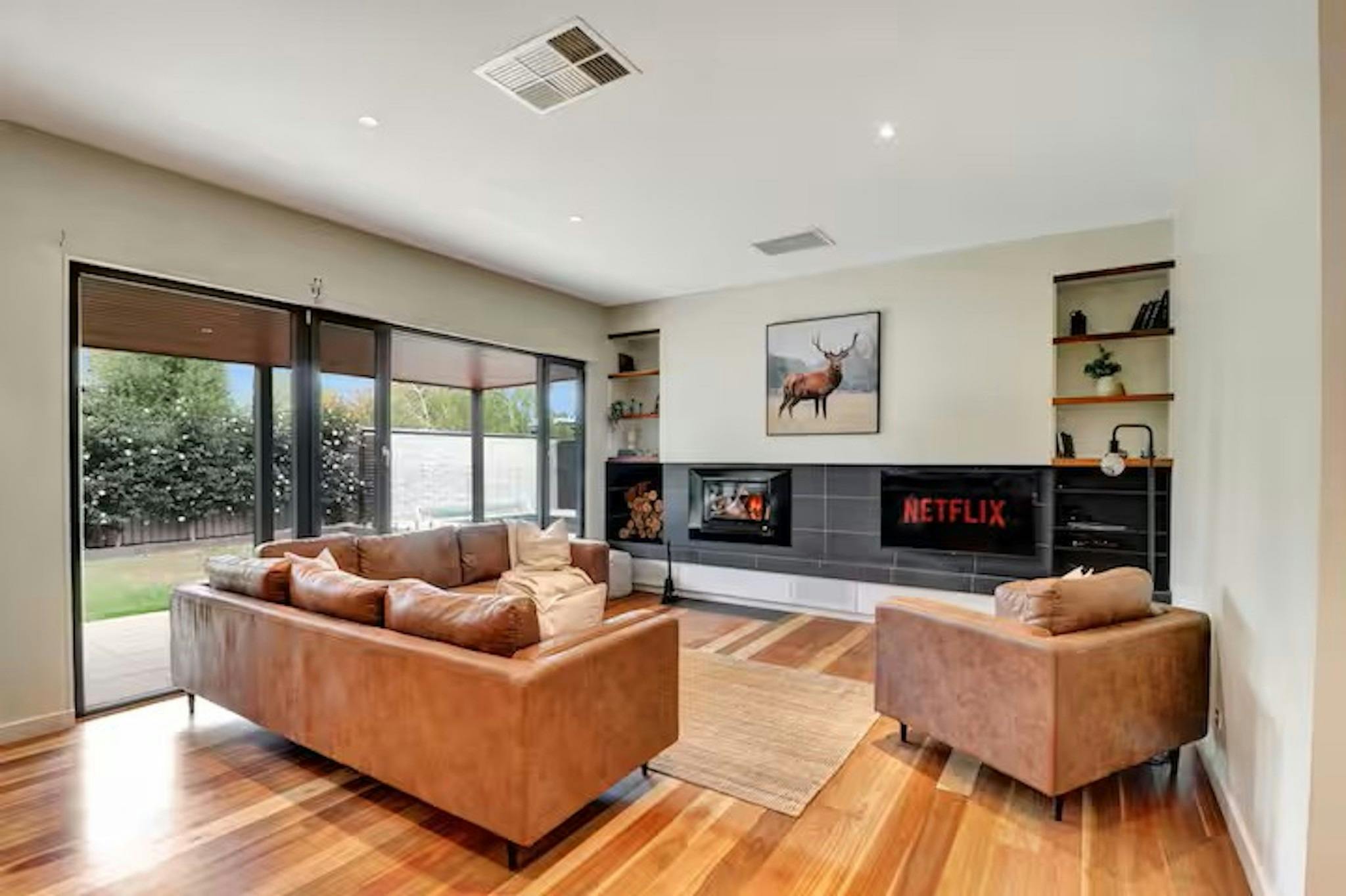 Spacious living room with fireplace at Banksia House holiday accommodation Mansfield