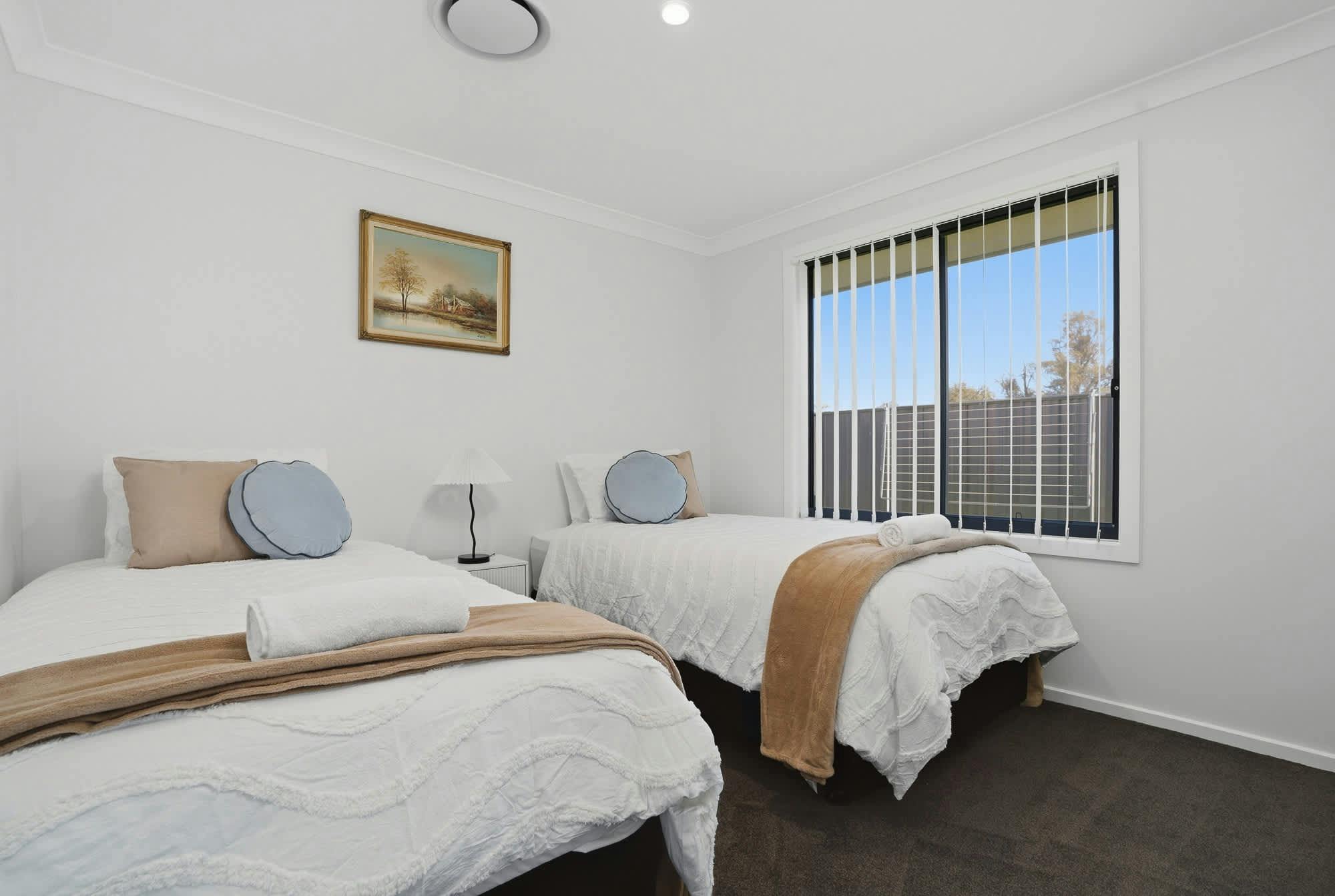 2 King singles with white doonas, beige pillow, throw and blue pillows