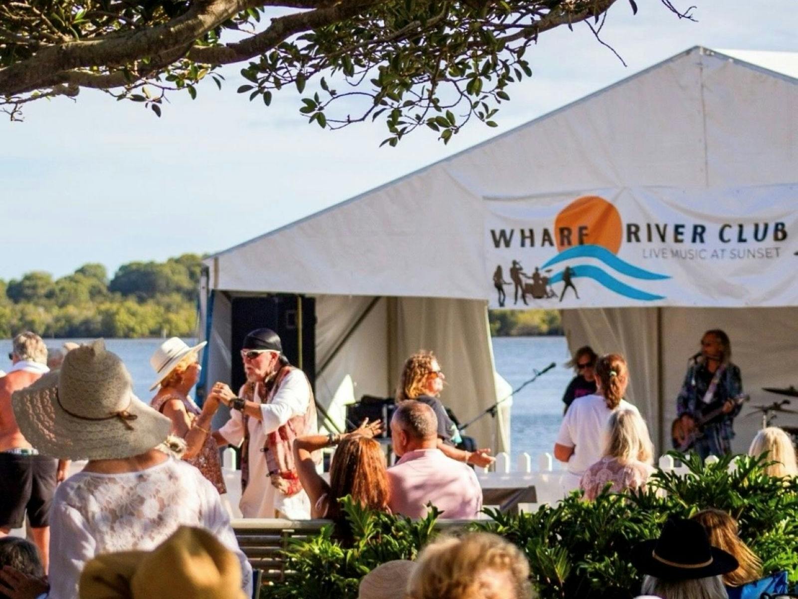 people dancing in front of musicians playing on wharf