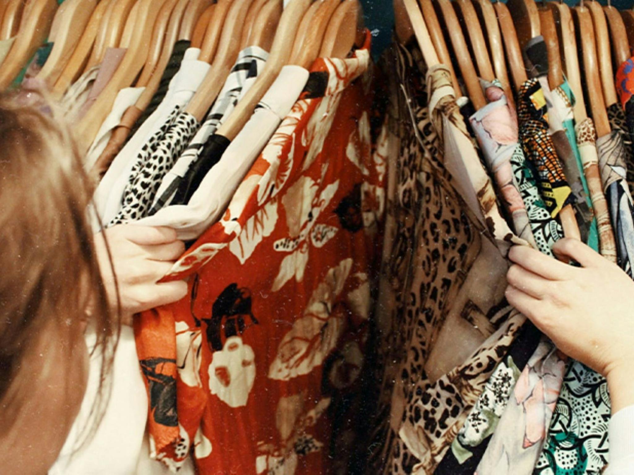 Image of a woman rifling through a rack of dresses