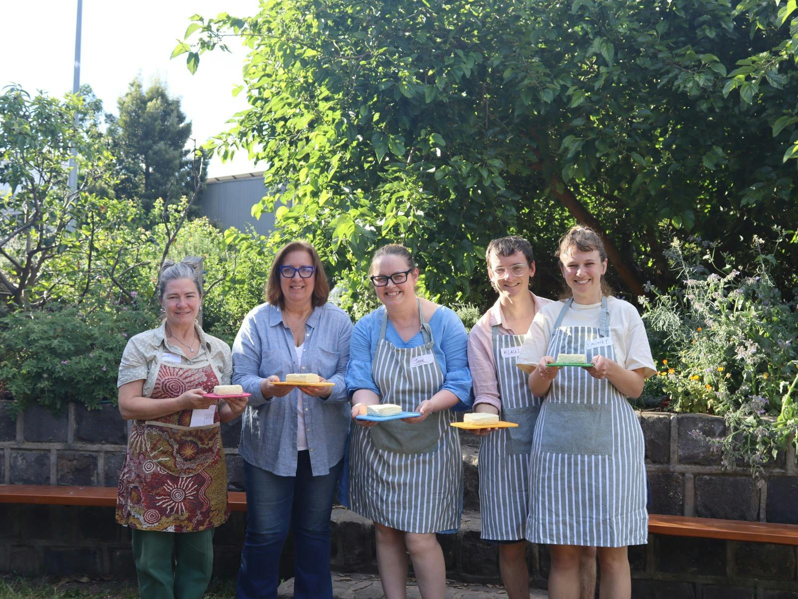 A group of students show off their finished cheese