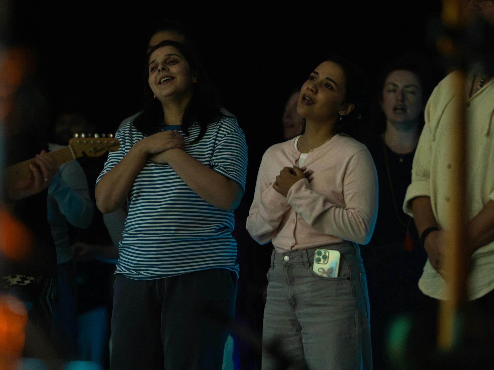 Two women singing, hands to heart