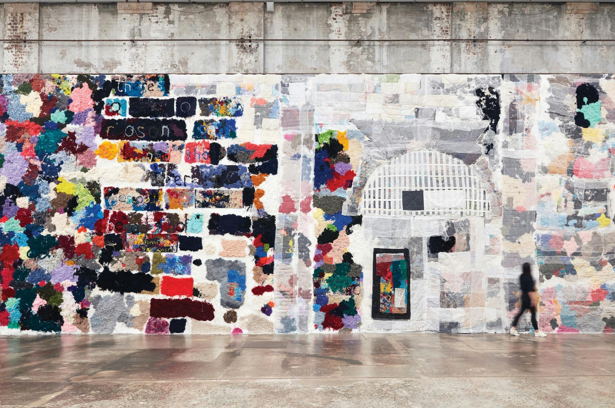 A wall covered in knitted patches of textiles
