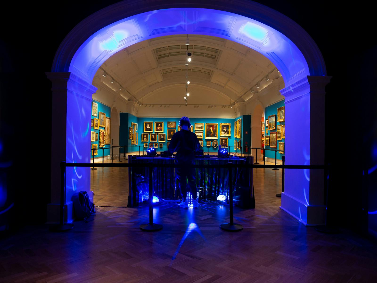 DJ with turntables in a paintings gallery