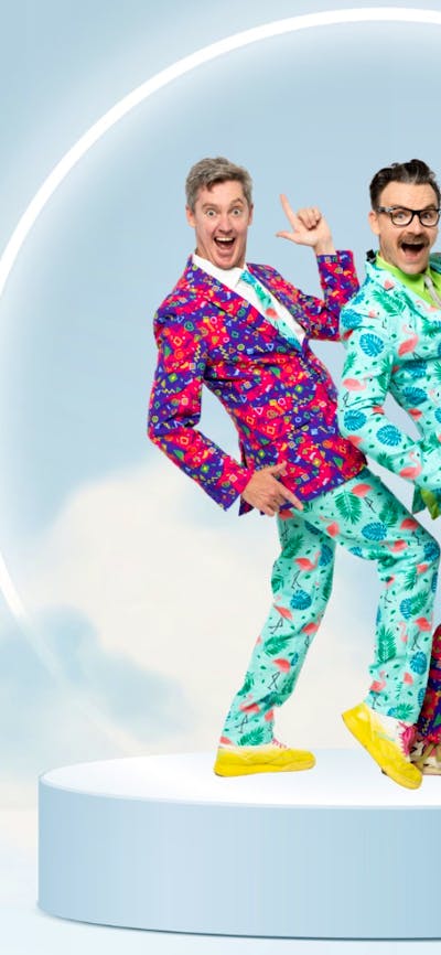 Two men stand on a platform in colourful suits surrounded by a white glowing circle and clouds