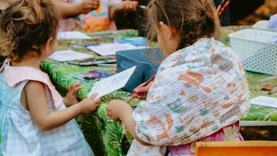 Children sitting around a table doing colouring in activities