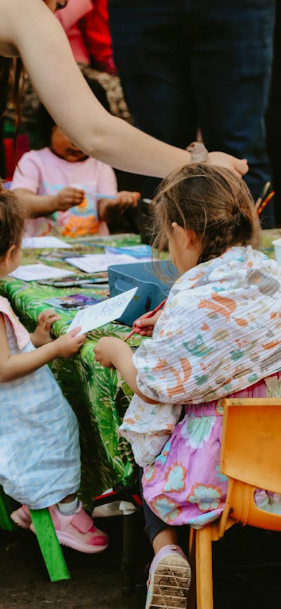 Children sitting around a table doing colouring in activities