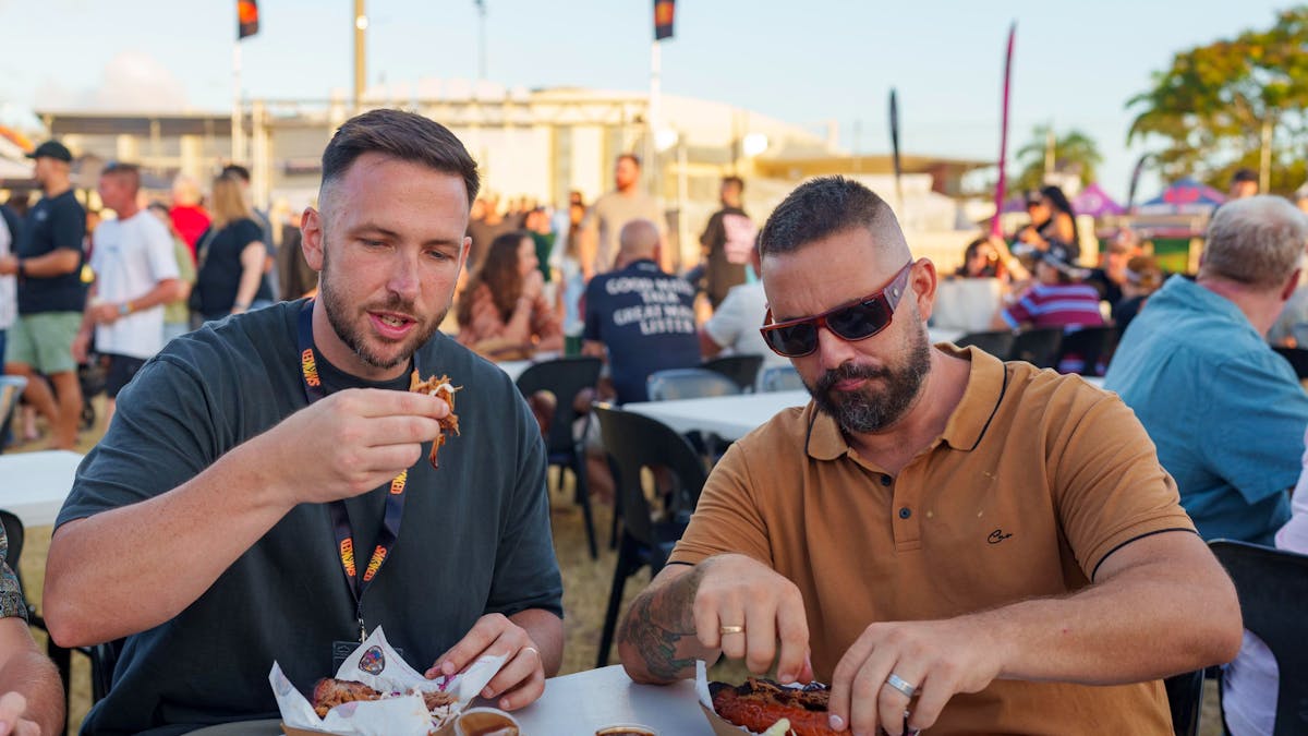 2 men eating meat