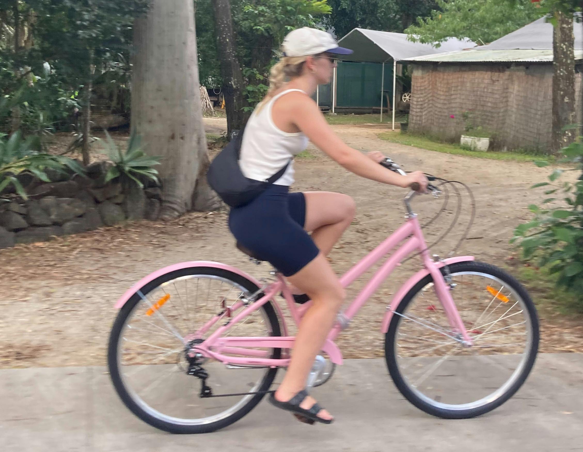 Pauline riding her pink bike in Byron Bay