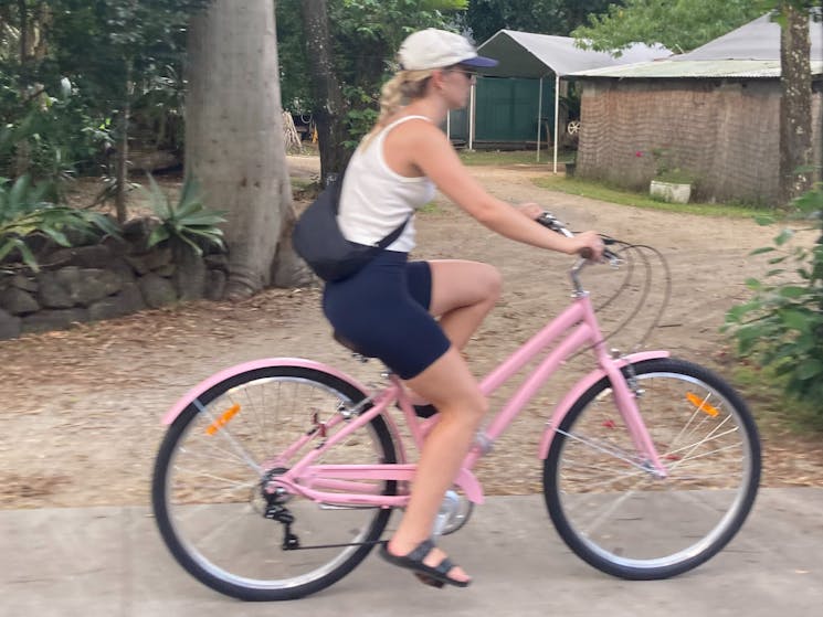 Pauline riding her pink bike in Byron Bay