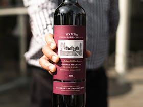 A bottle of Wynns Cabernet Sauvignon 2012 held out in front towards the camera