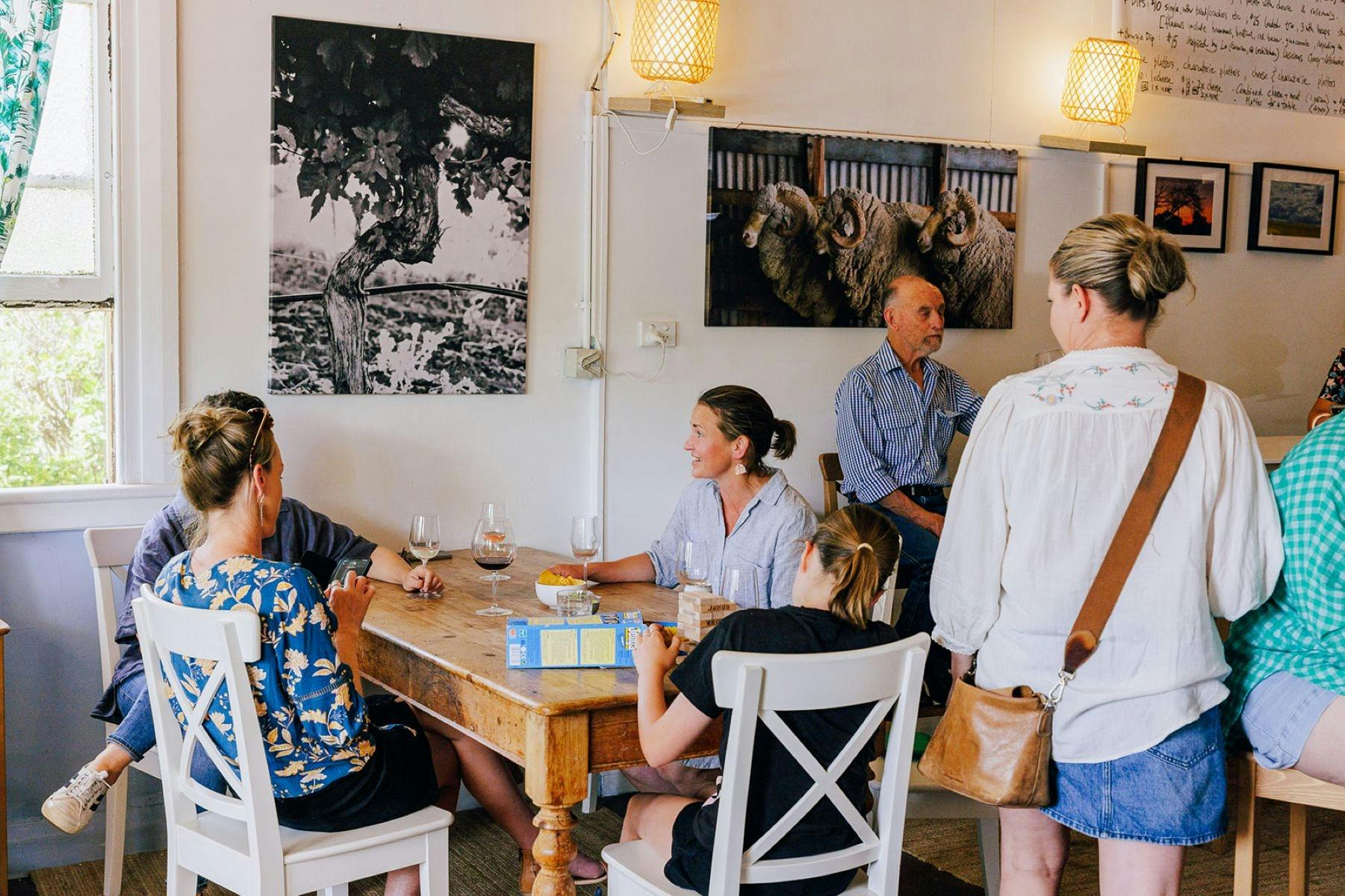 Buzzing interior with multiple people enjoying a chat & glass of wine. A child is playing Jenga.