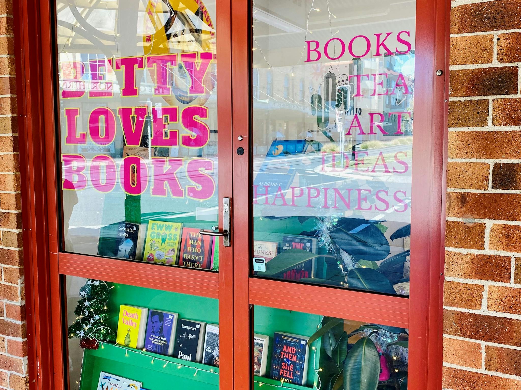 A window display saying Betty Loves Books and books, tea, art, happiness